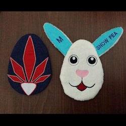 ITH bunny head with blue ears and pink nose, playful and colorful design, accompanied by a red leaf egg shape for Easter.