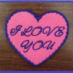 ITH heart-shaped patch in vibrant pink with dark blue border and 'I LOVE YOU' text, perfect for Valentine's Day.