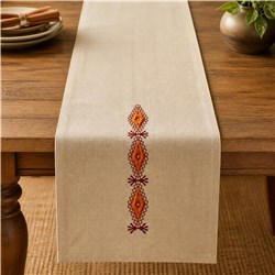 Modern table runner in light beige with intricate orange and red embroidered designs, perfect for fall decor.